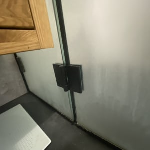 דלת זכוכית למקלחת עם ידית שחורה