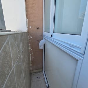 מרפסת עם חלון אלומיניום וקיר אריחים
