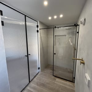 מקלחון זכוכית עם דלתות שקופות בחדר אמבטיה מודרני