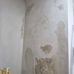 קיר עם טיח מתקלף ותיקונים נדרשים לצביעה