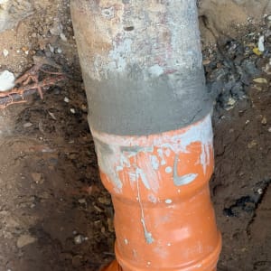 חיבור צינור ביוב כתום חדש לתשתית צנרת באדמה