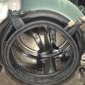 תוף מכונת כביסה פתוח עם חלקים פנימיים