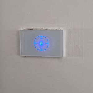 מתג חשמלי עם תאורה כחולה על קיר לבן