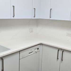 מטבח עם משטח שיש לבן וכיור נירוסטה