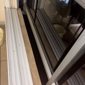 חלון נקי עם מסגרת מתכת ודלי צהוב