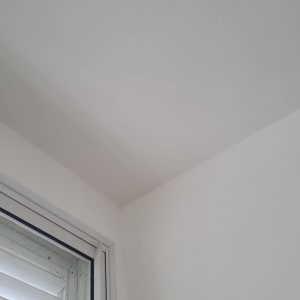 קיר ותקרה צבועים בלבן ליד חלון