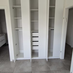 ארון בגדים לבן עם מדפים ומגירות פתוחים