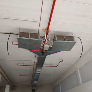 תעלות מיזוג אוויר תלויות בתקרה עם צינורות חשמל