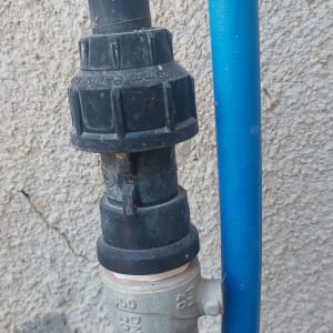צינור מים עם מחבר על קיר חיצוני