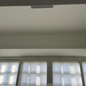 חלון עם תריסים סגורים ותקרה לבנה