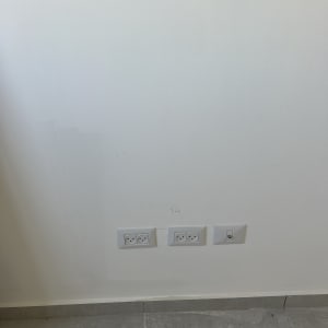 שני שקעים כפולים ושקע אחד על קיר לבן