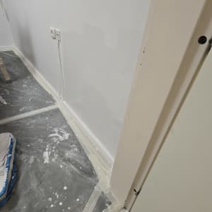 קיר צבוע עם רצפה מכוסה בניילון להגנה.