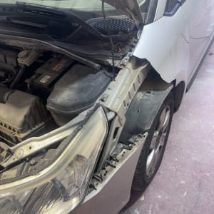 רכב עם מכסה מנוע פתוח ותיקון פגוש קדמי