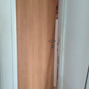 דלת עץ חומה עם ידית מתכת כסופה