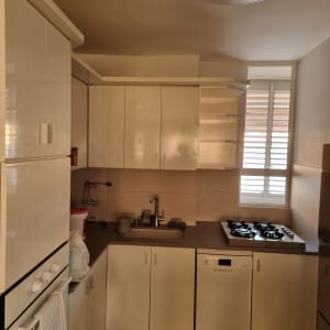 מטבח עם ארונות לבנים וכיריים גז