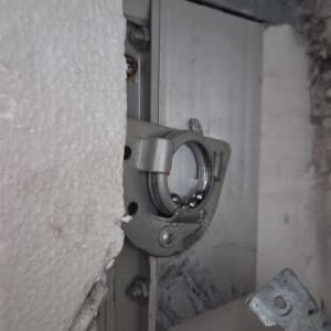 חלק מתכת בתוך מסגרת עם קלקר וקיר