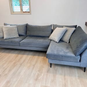 ספה אפורה עם כריות על רצפת עץ