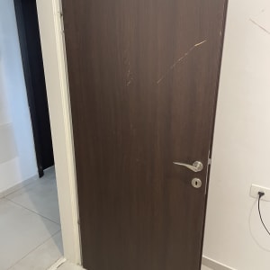 דלת עץ חומה עם ידית מתכת כסופה