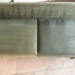 ספה ירוקה עם סימני ניקוי נראים לעין