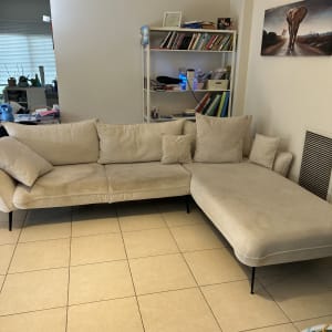 ספה בהירה בחדר מגורים עם מדף ספרים