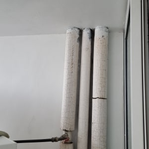 צינורות עם צבע מתקלף על קיר לבן