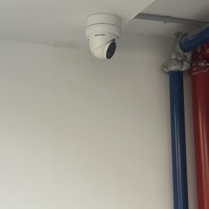 מצלמת אבטחה מותקנת על תקרה ליד צינורות צבעוניים
