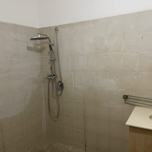 חדר אמבטיה עם מקלחת וכיור, מתאים לשיפוץ