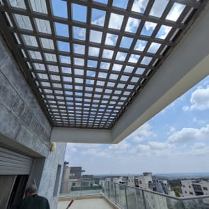 מרפסת עם גג סריג ואדם בכניסה
