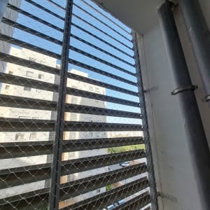 רשת מתכת על חלון למניעת כניסת יונים