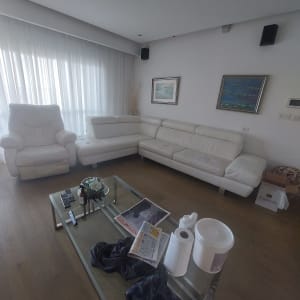 מוצרי ניקוי על שולחן ליד ספות לבנות