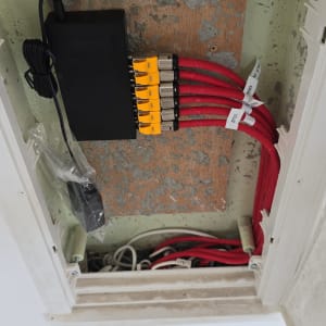 ארון תקשורת עם כבלים אדומים ומחברים צהובים