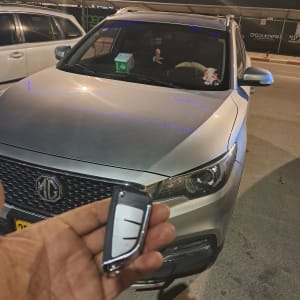 מפתח רכב חכם מול מכונית חונה בלילה