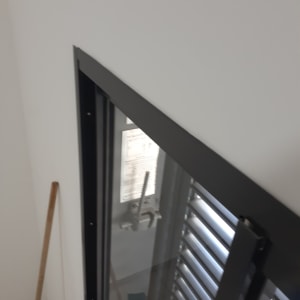 מקל מטאטא ליד חלון עם תריסים