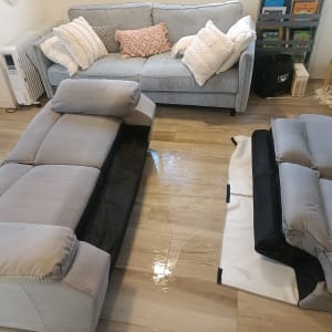 ספות אפורות בתהליך ניקוי בסלון ביתי