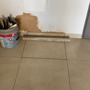 קיר עם תיקון טיח, דלי כלים ומוט עץ