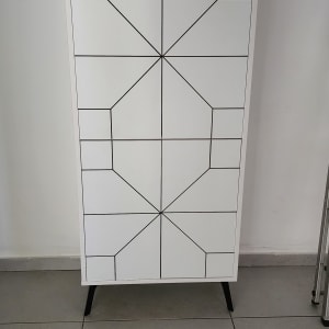 ארון לבן עם דלתות מעוצבות בקווים גיאומטריים