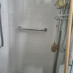 מקלחת עם ידית אחיזה ומדף לסבונים