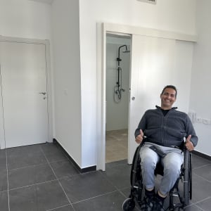 דלת לבנה סגורה ודלת הזזה פתוחה לחדר רחצה