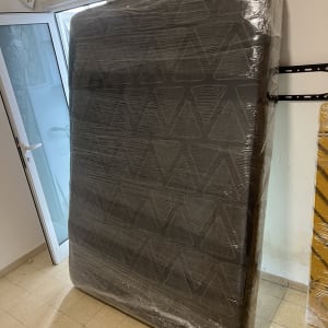 מזרן עטוף בניילון עומד ליד דלת פתוחה
