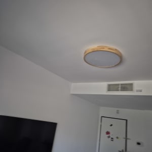 מנורה עגולה על תקרה בחדר עם טלוויזיה ומזגן