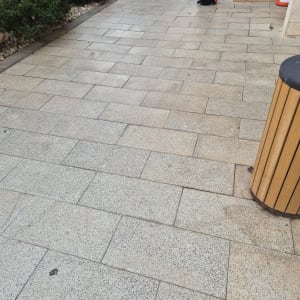 ניקוי ריצוף חוץ באבן משתלבת המציג קו הפרדה בין משטח מלוכלך למנקה
