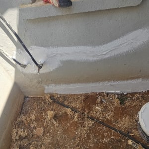 איטום סדקים בקיר חיצוני בבית קרקע עם חומר איטום ייעודי