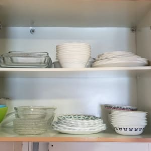 ארון מטבח פתוח עם קערות וזכוכית מסודרות