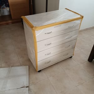 ארון עטוף בניילון מוכן להובלה על רצפת קרמיקה
