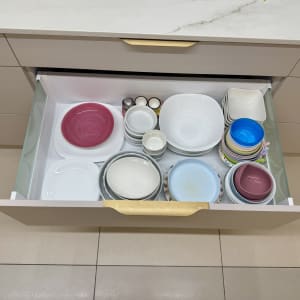 מגירה פתוחה עם צלחות וקערות מסודרות בצבעים שונים