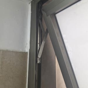 חלון פתוח עם מסגרת מתכת וקיר לבן