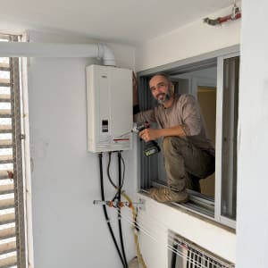 אדם מתקין מערכת גז ליד חלון