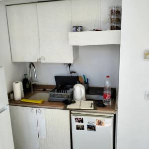 מטבח קטן עם כיור, קומקום וכלים על השיש