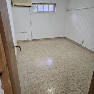 חדר ריק עם רצפת קרמיקה וקירות לבנים