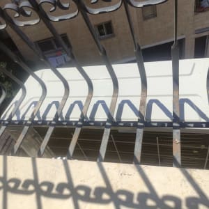 יחידת מזגן חיצונית מאחורי סורגי מתכת